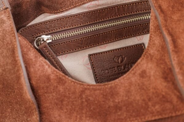 cartera-clarisse-gamuza-pelo-vaca-cuero-chocolate-interior-forro-rose-blanche.jpg Interior Cartera Clarisse Rose Blanche chocolate, forro estampado patrón Rose Blanche con bolsillo cremallera y etiqueta de cuero, artesanal Patagonia