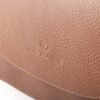 bandolera-ana-cuero-vacuno-camel-detalle-logo-rose-blanche.jpg Detalle logo Rose Blanche Origen Patagonia estampado en relieve sobre solapa, Bandolera Ana cuero vacuno camel artesanal