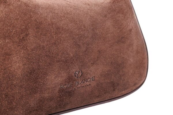 cartera-emma-gamuza-chocolate-detalle-logo-rose-blanche.jpg Detalle logo Rose Blanche Origen Patagonia estampado en gamuza chocolate, Cartera Emma artesanal Argentina