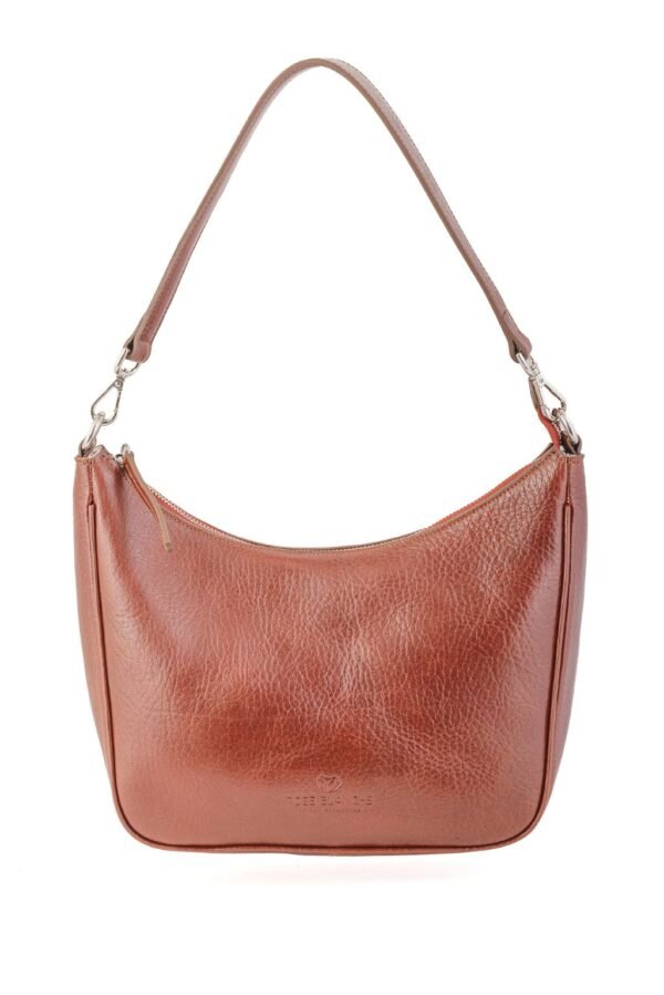 cartera-emma-cuero-vacuno-cognac-frontal-rose-blanche.jpg Cartera Emma Rose Blanche cognac cuero vacuno, vista frontal con correa de hombro, diseño artesanal Patagonia