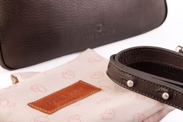 cartera-emma-cuero-vacuno-negro-detalle-logo-bolsa-rose-blanche.jpg Detalle Cartera Emma Rose Blanche cuero vacuno negro con bolsa de protección y correa removible, artesanal Patagonia
