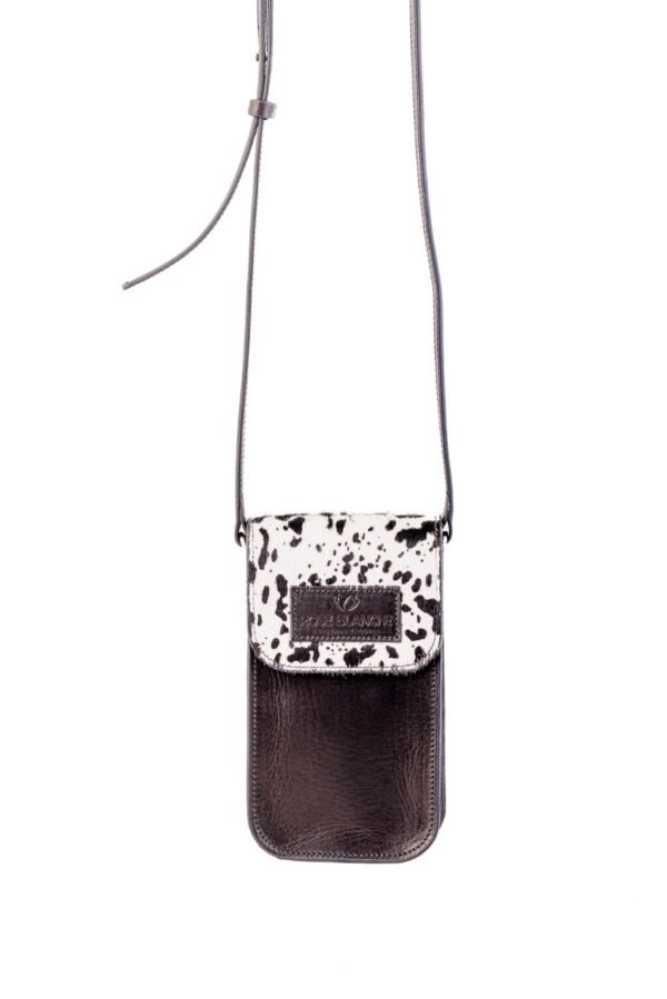 portacelular-alheli-pelo-vaca-manchas-negro-cuero-negro-correa-rose-blanche.jpg Portacelular Alhelí Rose Blanche pelo vaca manchas negro y cuero vacuno negro, con correa larga regulable, crossbody artesanal Patagonia