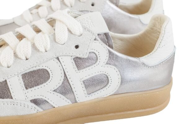 Detalle logo RB en cuero blanco sobre panel plateado, Zapatilla Emma Rose Blanche